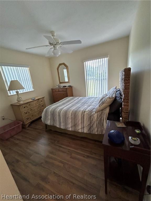 bedroom with ceiling fan and dark wood-type flooring