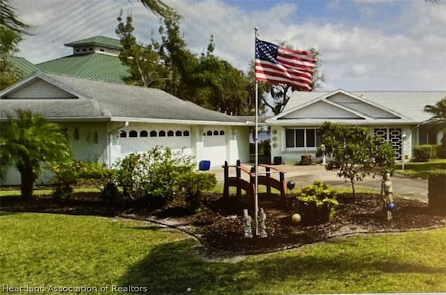 view of front of property with a front lawn and a garage