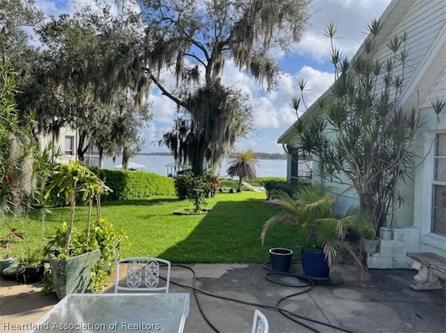 view of yard with a water view and a patio area