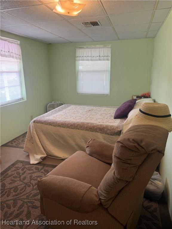 bedroom with carpet flooring and a paneled ceiling