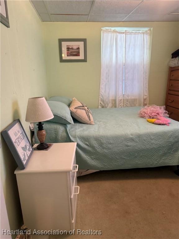 carpeted bedroom featuring a paneled ceiling