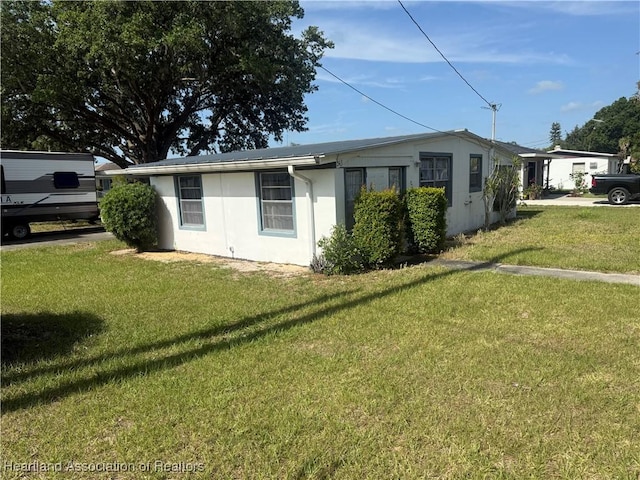 view of property exterior featuring stucco siding and a yard