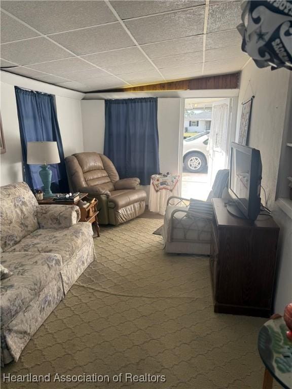 carpeted living area featuring a drop ceiling