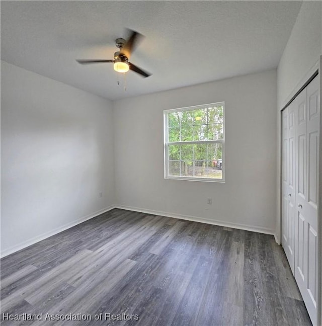 3040 W Joliet Rd, Avon Park, FL 33825 - unfurnished bedroom featuring dark wood-style flooring, a closet, ceiling fan, and a textured ceiling
