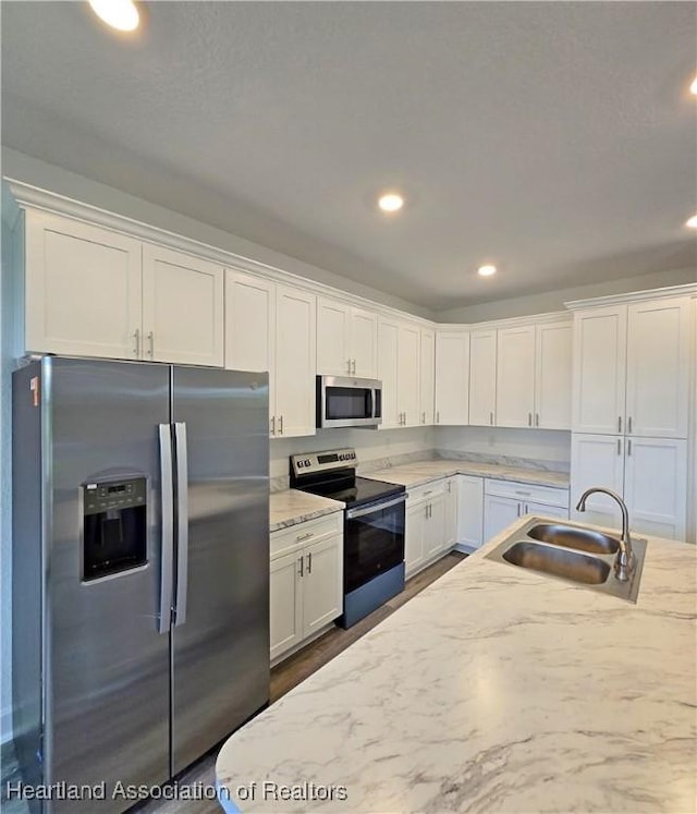 3040 W Joliet Rd, Avon Park, FL 33825 - kitchen with stainless steel appliances, white cabinetry, recessed lighting, light stone counters, and dark wood-style floors