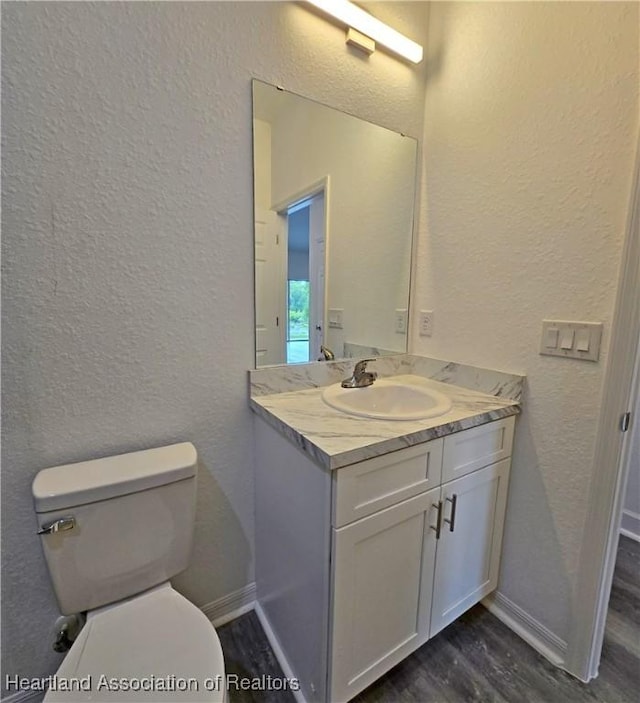 3040 W Joliet Rd, Avon Park, FL 33825 - bathroom featuring a textured wall, wood finished floors, and vanity