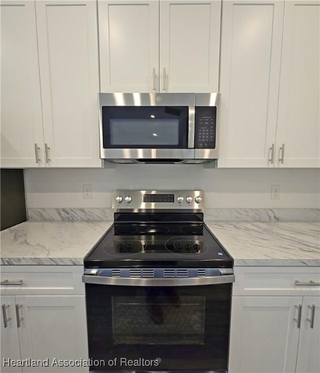 3040 W Joliet Rd, Avon Park, FL 33825 - kitchen featuring appliances with stainless steel finishes, white cabinets, and light stone countertops