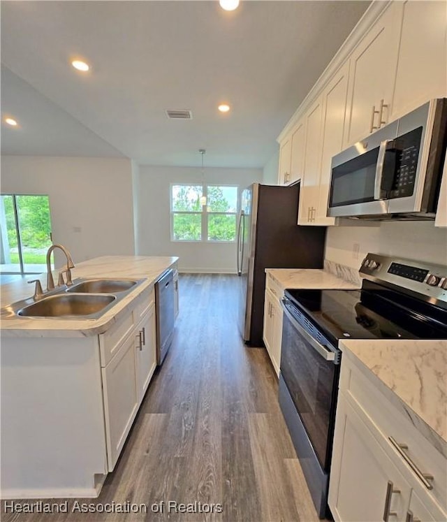 3040 W Joliet Rd, Avon Park, FL 33825 - kitchen with stainless steel appliances, dark wood-style flooring, white cabinetry, recessed lighting, and a kitchen island with sink
