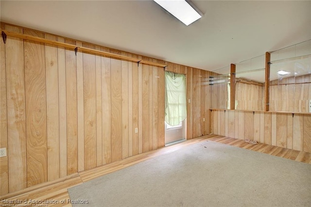 unfurnished room with wood walls and lofted ceiling