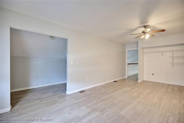 spare room with light wood-type flooring and ceiling fan