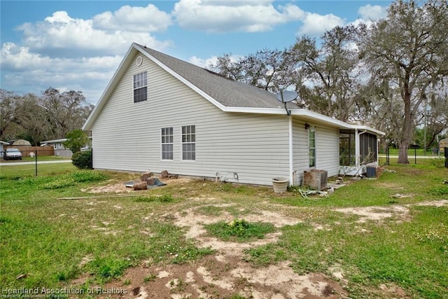 view of side of home featuring a sunroom and a yard