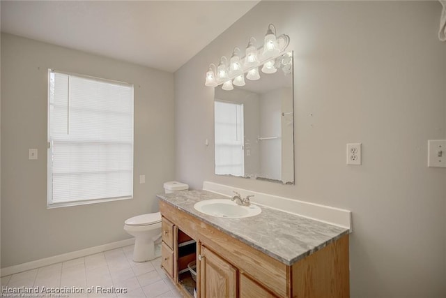 bathroom with tile patterned floors, plenty of natural light, vanity, and toilet