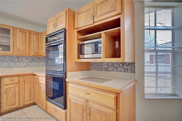 kitchen featuring light tile patterned floors, backsplash, double oven, and light brown cabinets