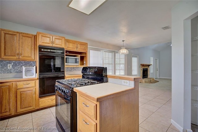 kitchen featuring black appliances, a center island, light tile patterned flooring, and pendant lighting