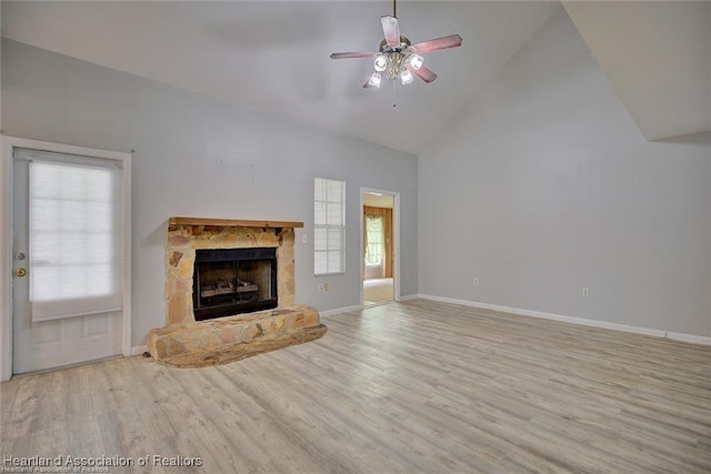 unfurnished living room featuring ceiling fan, a fireplace, high vaulted ceiling, and light hardwood / wood-style flooring