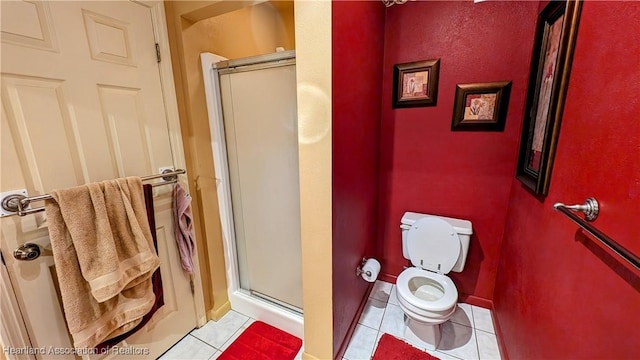 bathroom featuring tile patterned floors, an enclosed shower, and toilet