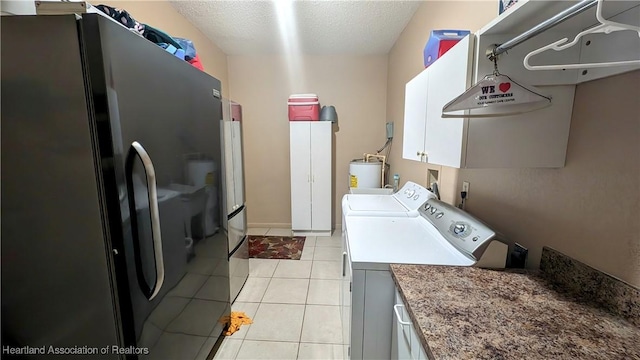 laundry room with cabinets, separate washer and dryer, water heater, a textured ceiling, and light tile patterned floors