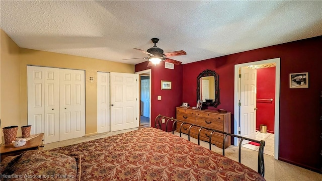 bedroom with ceiling fan, light carpet, and a textured ceiling