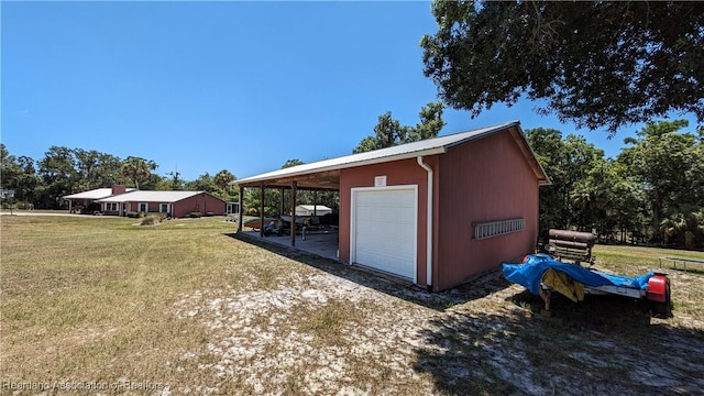 view of outbuilding with a yard and a carport