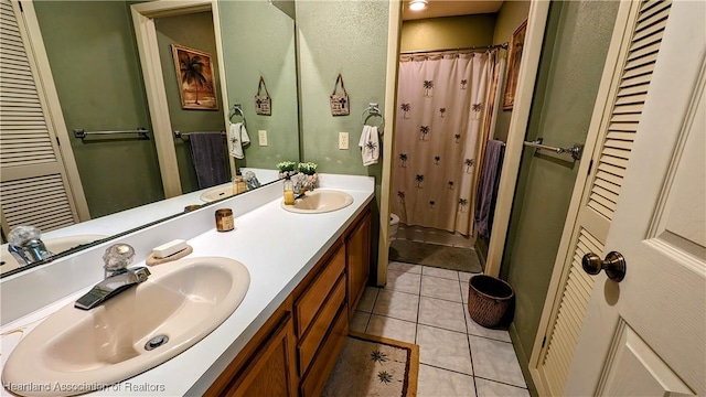 bathroom with a shower with curtain, vanity, and tile patterned floors