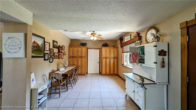 kitchen with ceiling fan, light tile patterned flooring, and a textured ceiling