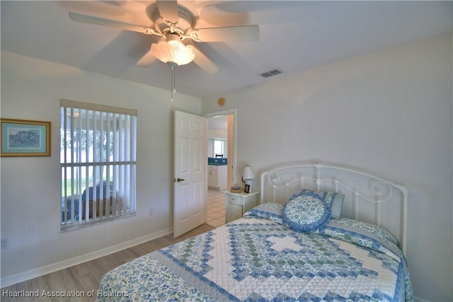 bedroom with baseboards, ceiling fan, visible vents, and light wood-style floors