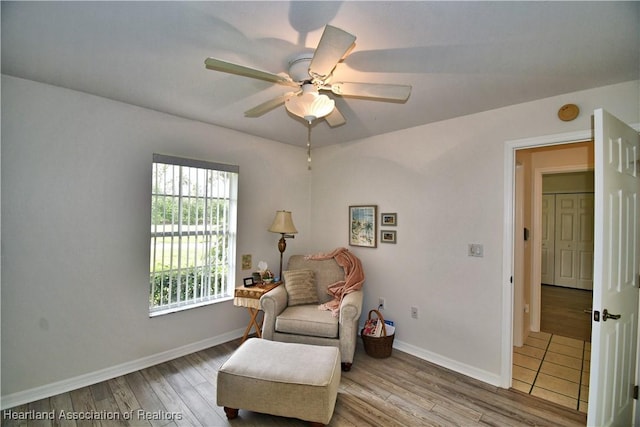 sitting room with ceiling fan, light wood-style flooring, and baseboards