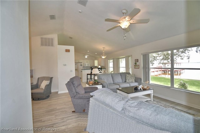 living area with light wood-type flooring, lofted ceiling, visible vents, and ceiling fan