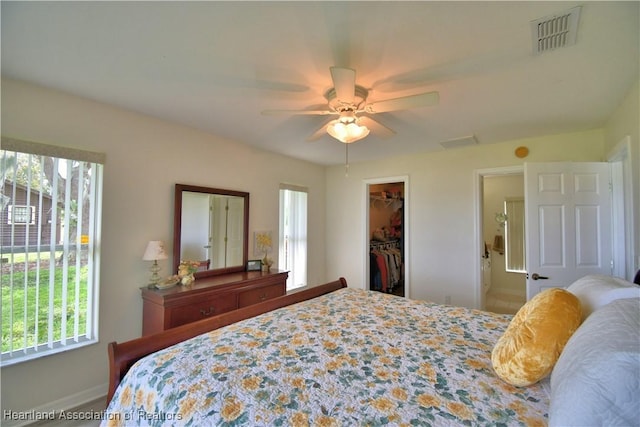 bedroom with ceiling fan, visible vents, a walk in closet, and a closet