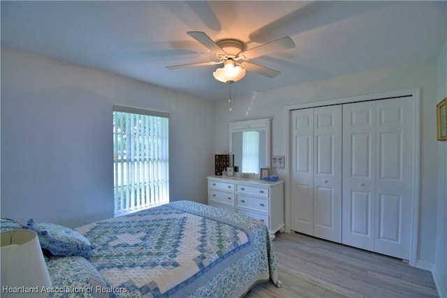 bedroom featuring ceiling fan, light wood finished floors, and a closet