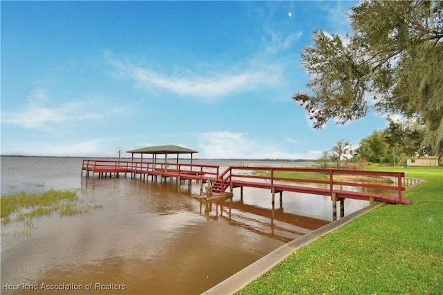 dock area featuring a lawn and a water view