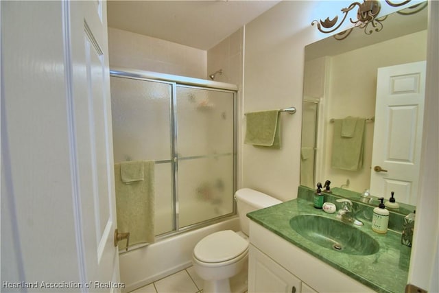 full bathroom featuring toilet, tile patterned floors, combined bath / shower with glass door, and vanity