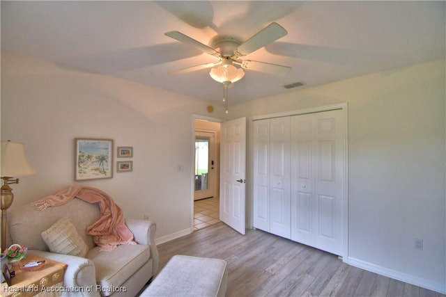 interior space featuring ceiling fan, light wood finished floors, visible vents, and baseboards