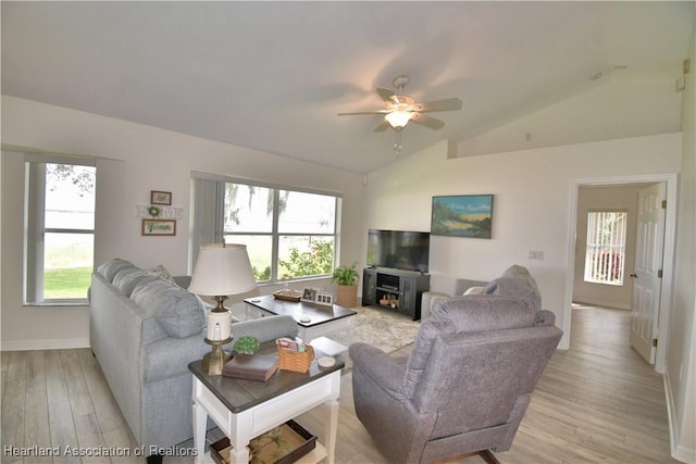 living room with vaulted ceiling, light wood-type flooring, and a wealth of natural light