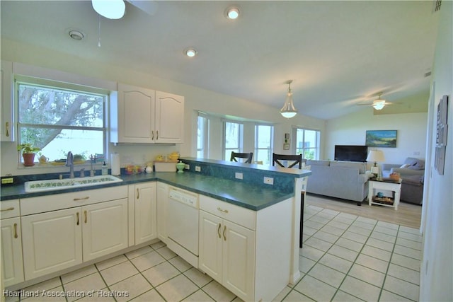 kitchen with dark countertops, white cabinetry, white dishwasher, and a sink