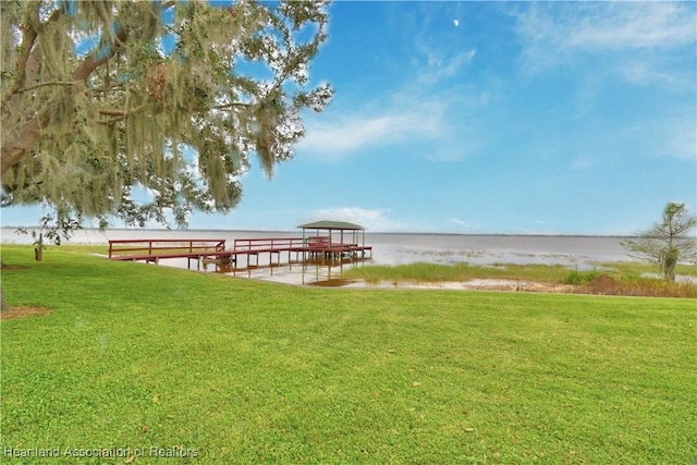 view of dock featuring a water view and a lawn