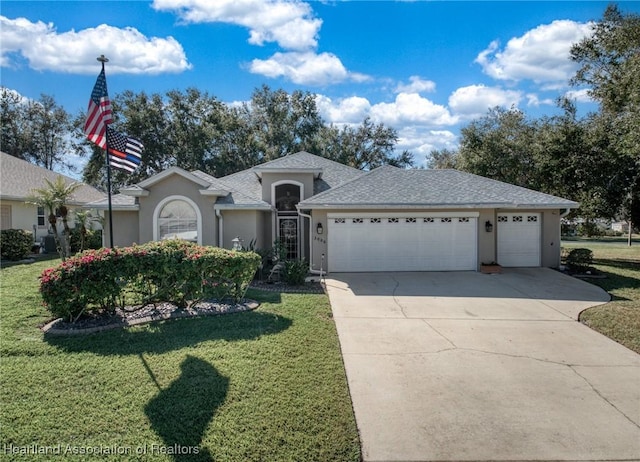 single story home featuring a front lawn and a garage