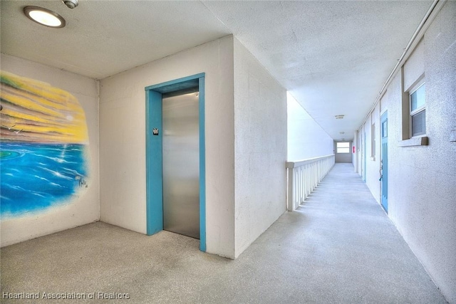 hall featuring elevator, a textured ceiling, and a textured wall