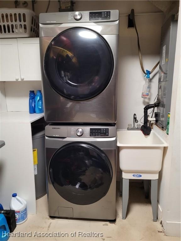 laundry room featuring stacked washer and dryer and sink