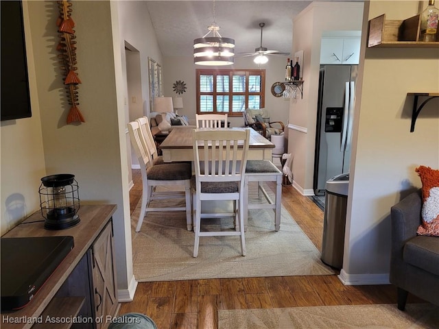 dining room with lofted ceiling, ceiling fan, and light wood-type flooring