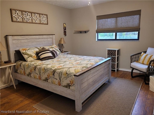 bedroom with dark hardwood / wood-style floors