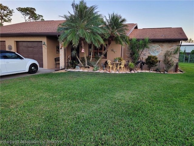 ranch-style home featuring a front yard and a garage