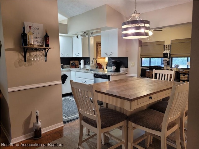 kitchen with sink, dark wood-type flooring, ceiling fan, hanging light fixtures, and white cabinets