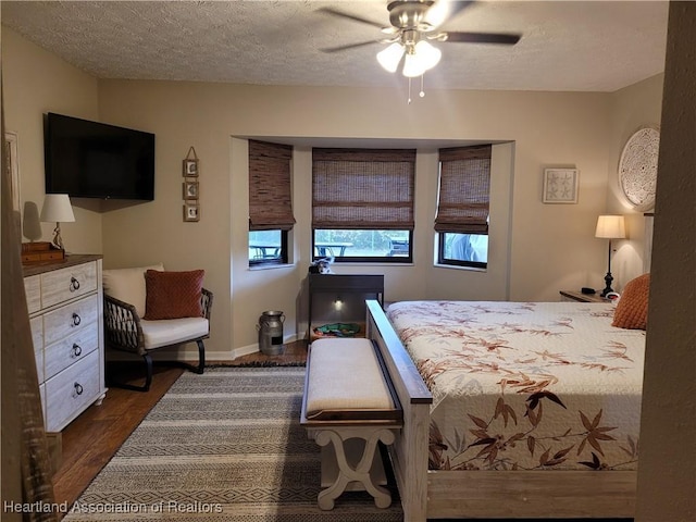 bedroom featuring dark hardwood / wood-style flooring, a textured ceiling, and ceiling fan