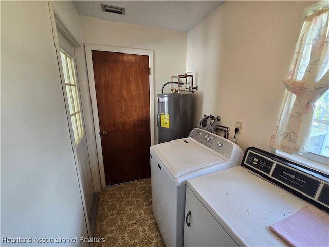 clothes washing area with washing machine and clothes dryer and electric water heater