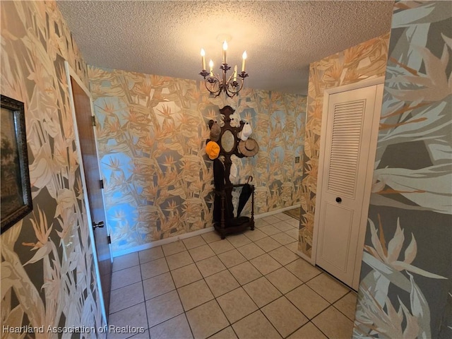 interior space featuring a chandelier, tile patterned floors, and a textured ceiling