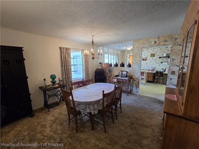 dining space with a chandelier, a textured ceiling, and dark colored carpet