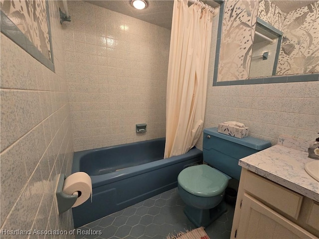 full bathroom with shower / bath combo, tile walls, vanity, tile patterned floors, and toilet