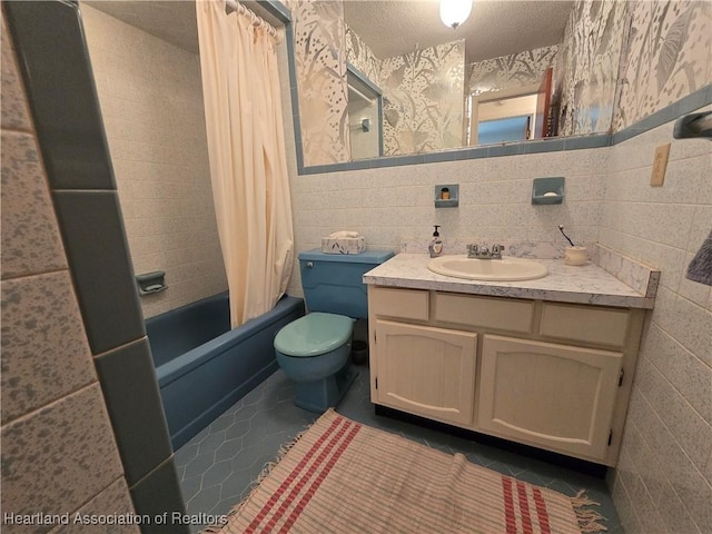 full bathroom featuring tile walls, tile patterned flooring, vanity, toilet, and a textured ceiling