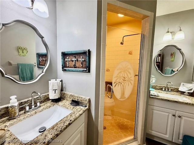 full bathroom featuring a stall shower, two vanities, and a sink